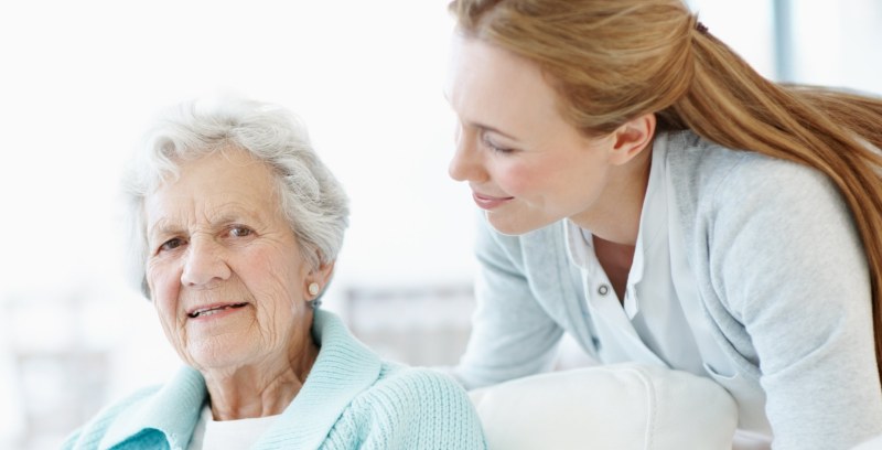 Daughter and her elderly mother laughing together
