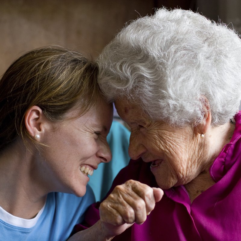 Daughter and her elderly mother laughing together